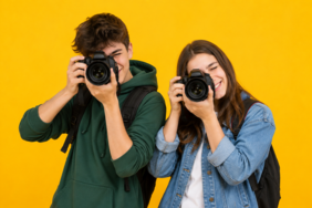 Ein Junge und ein Mädchen fotografieren mit einer Spiegelreflexkamera.